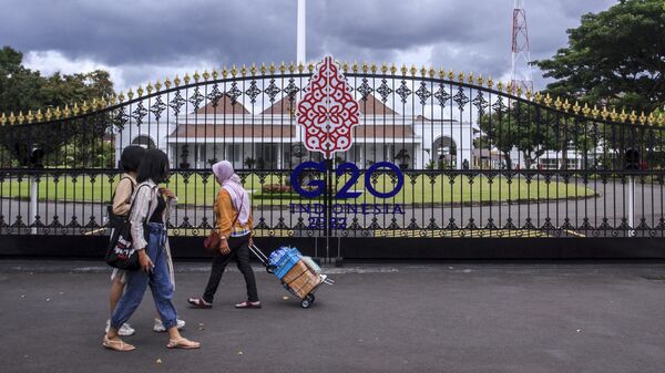 Люди проходят мимо главных ворот дворца Джокьякарты во время подготовки к саммиту G20 в Индонезии