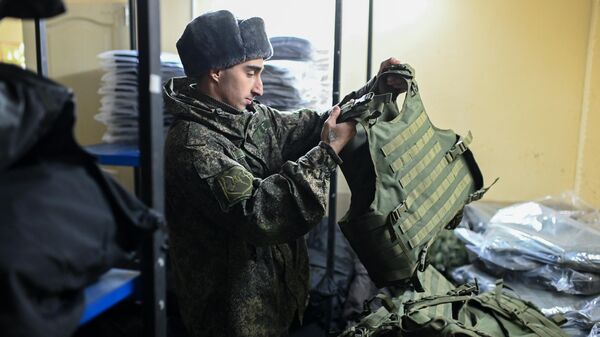 Военнослужащий ВС России во время выдачи комплекта боевой экипировки мобилизованного на пункте приема личного состава в Ростовской области