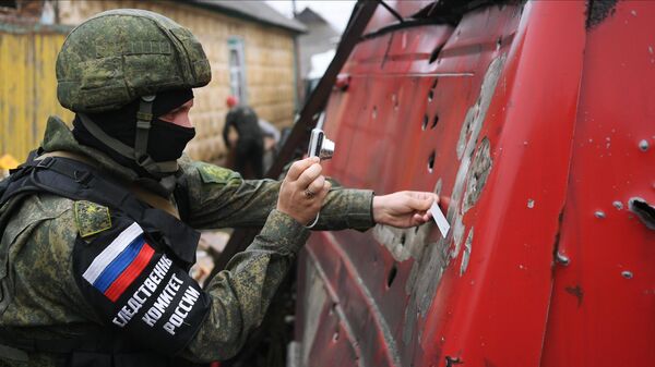 Сотрудник Следственного комитета РФ фиксирует последствия обстрелов в Донецке