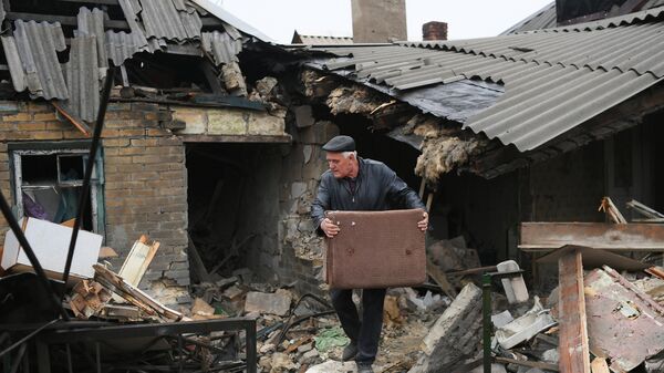 Местный житель во дворе разрушенного жилого дома в результате обстрела ВСУ в одном из пригородных районов Донецка