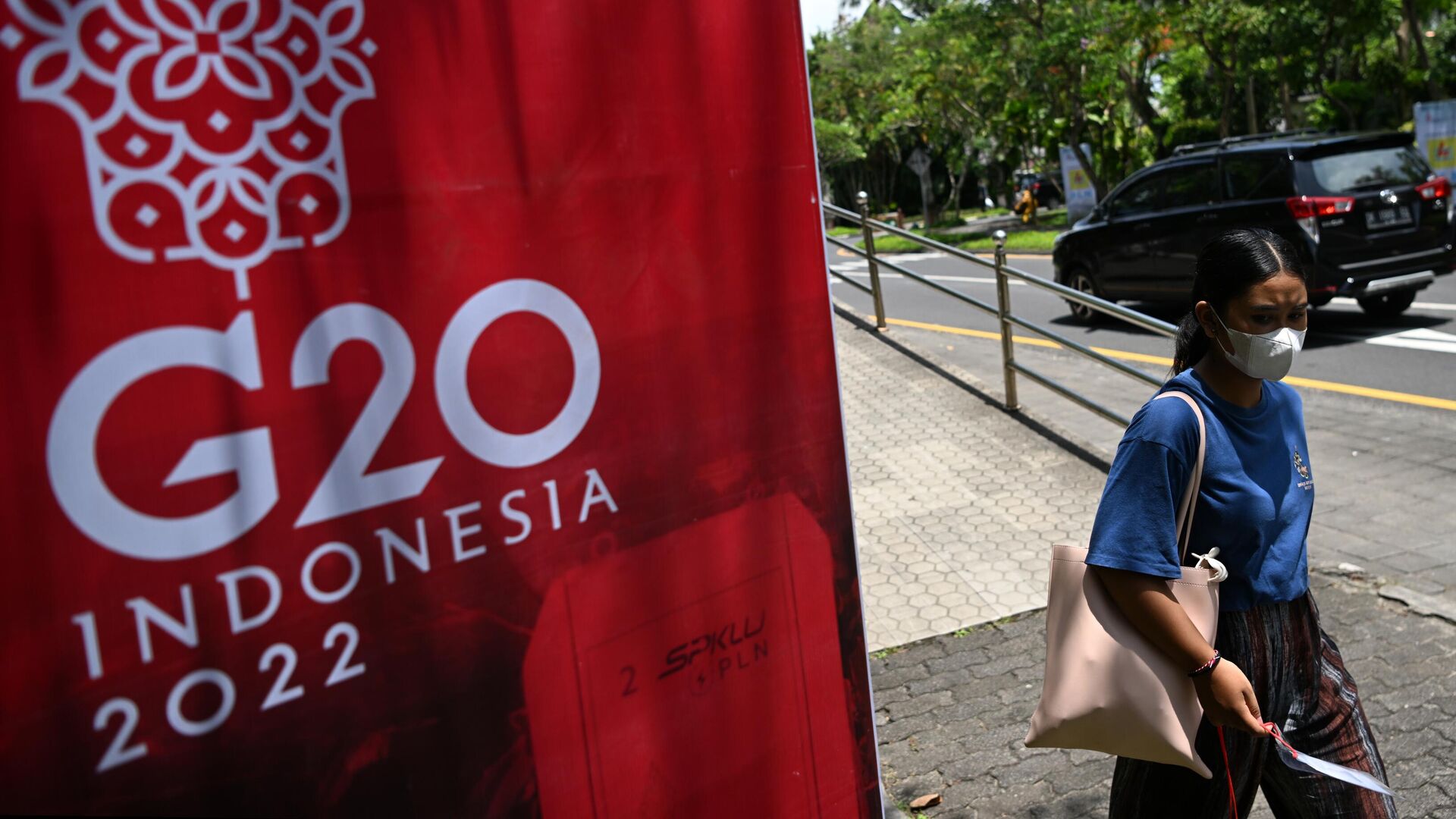 Девушка проходит мимо баннера, посвящённого саммиту G-20 на Бали - РИА Новости, 1920, 16.11.2022