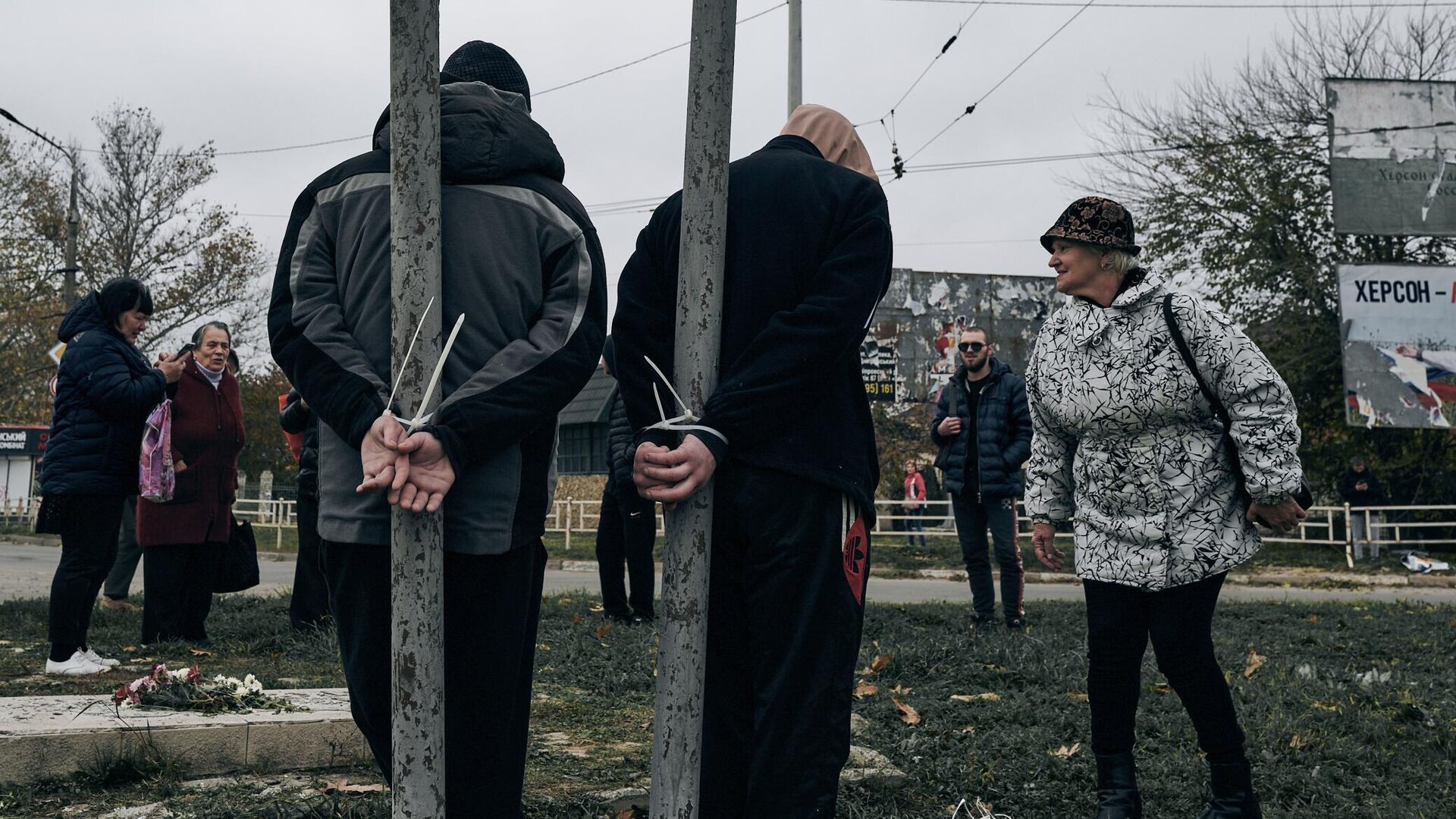 Жители Херсона, привязанные за руки к столбам на одной из улиц города - РИА Новости, 1920, 21.12.2022