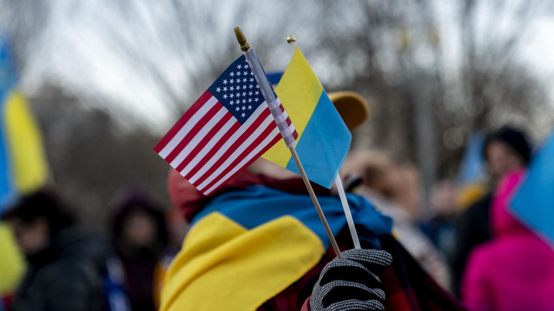 Человек держит флаги США и Украины перед Белым домом в Вашингтоне - РИА Новости, 1920, 16.11.2022