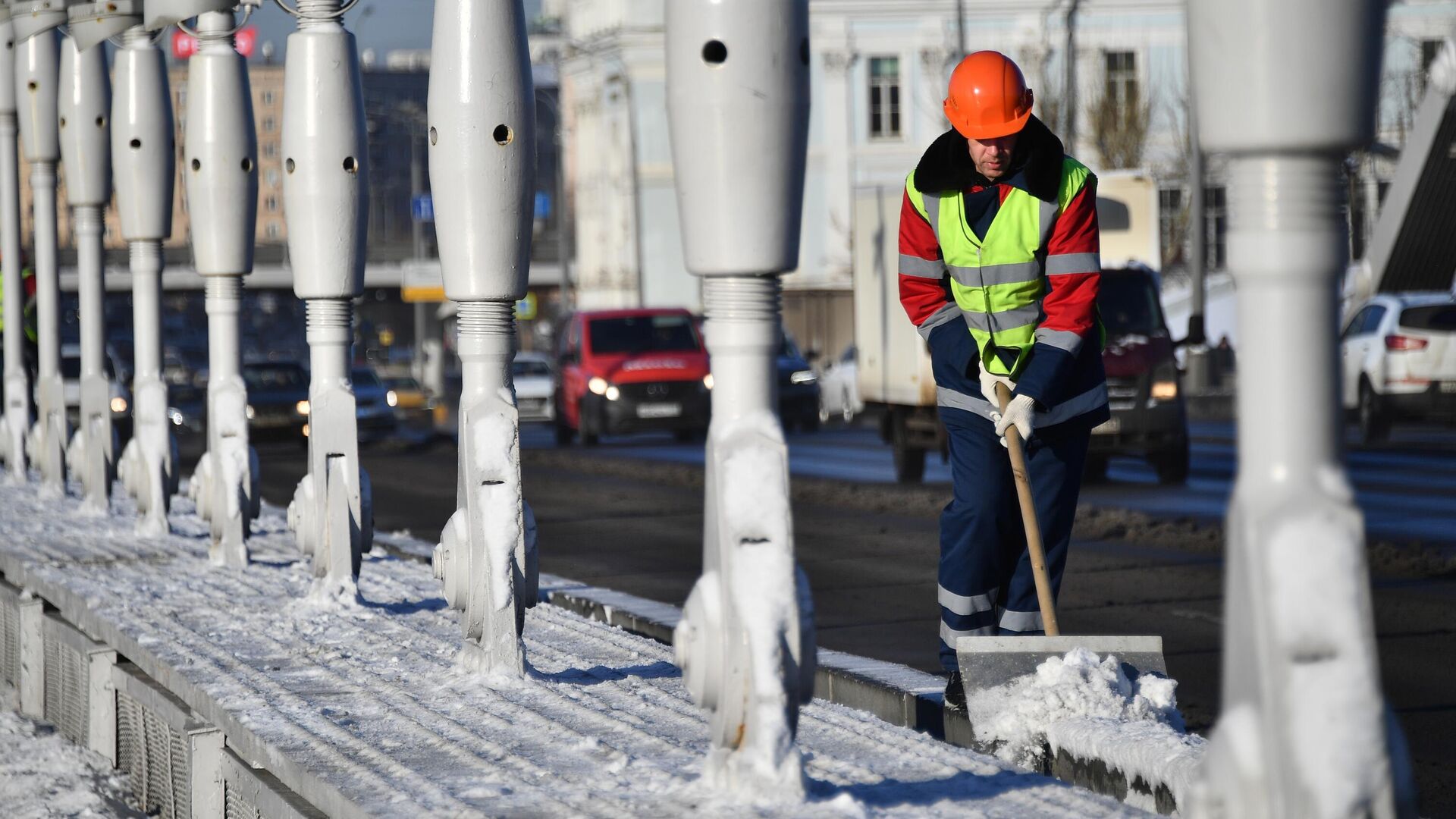 Сотрудник коммунальных служб чистит снег на Крымском мосту в Москве - РИА Новости, 1920, 19.12.2022