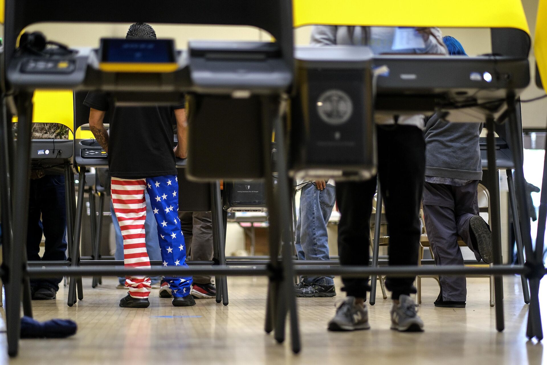 Мужчина в штанах в цвет флага США она избирательном участке в Лос-Анджелесе  - РИА Новости, 1920, 01.03.2024
