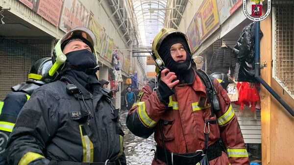 Сотрудники МЧС на месте пожара на рынке Садовод