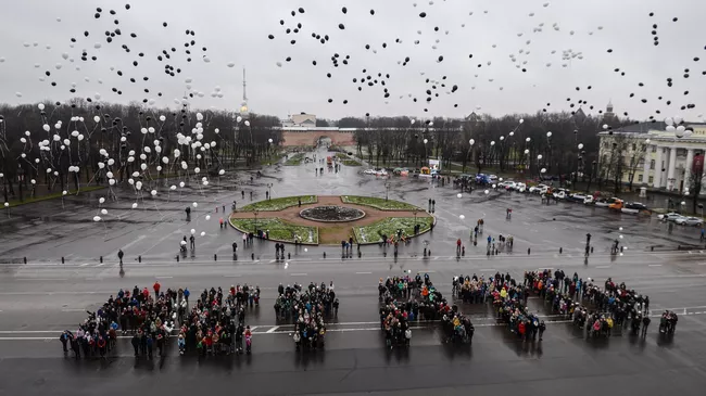 Участники акции, выстроившиеся в символическую надпись Нет ДТП!, выпускают черно-белые шары на площади Победы-Софийская во Всемирный день памяти жертв дорожно-транспортных происшествий в Великом Новгороде 