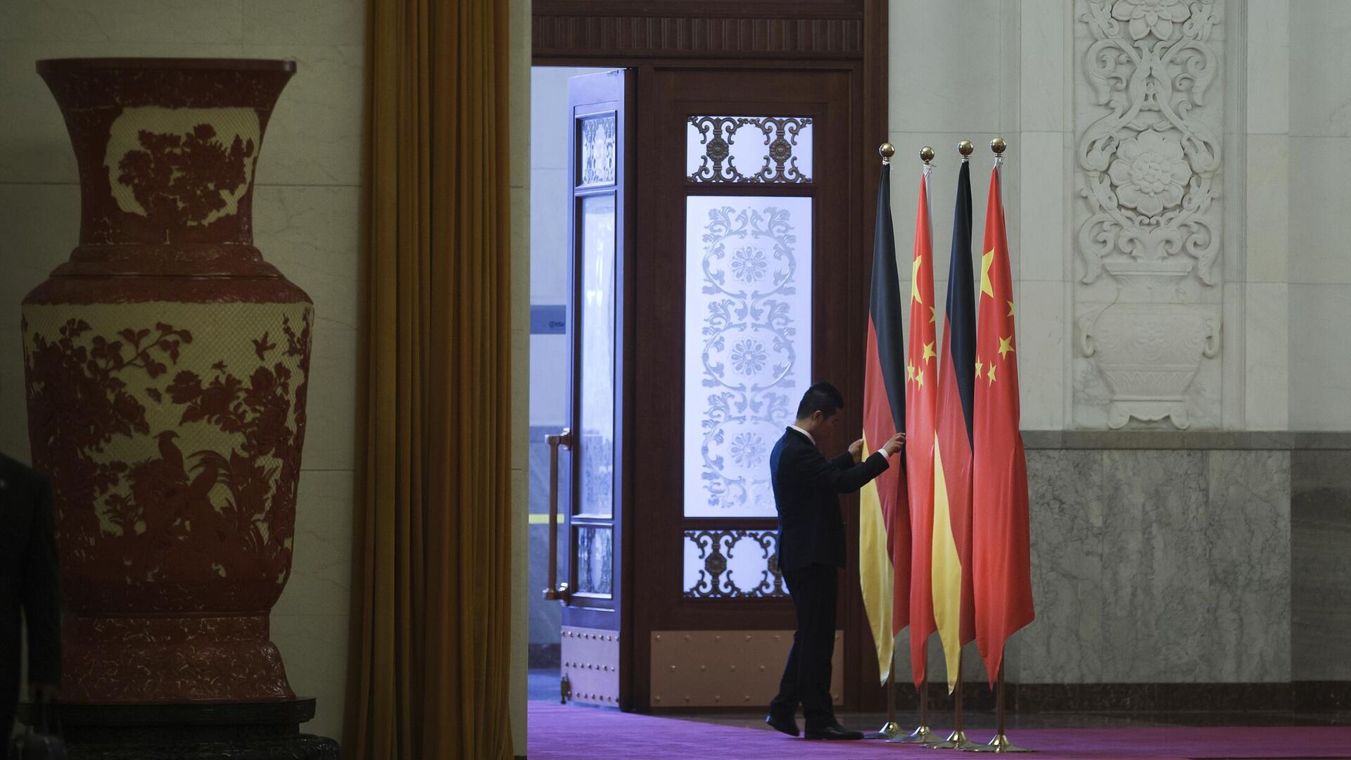 Работник поправляет флаги Германии и Китая в Доме народных собраний в Пекине - РИА Новости, 1920, 24.11.2022