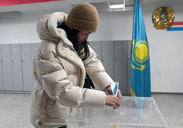 Девушка голосует на одном из избирательных участков в Астане на внеочередных выборах президента Казахстана