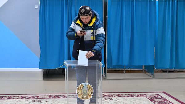 Мужчина голосует на одном из избирательных участков в Астане на внеочередных выборах президента Казахстана