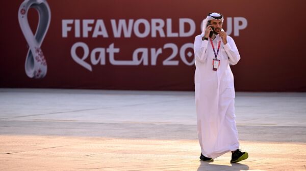 Мужчина на фоне официальной символики чемпионата мира по футболу у стадиона ЭльБайт (ЭльХаур) в Катаре, где пройдет церемония открытия ЧМ-2022 по футболу.