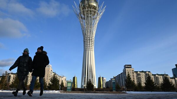 Люди гуляют у монумента Астана-Байтерек на бульваре Нуржол в Астане