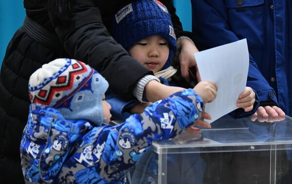 Дети на одном из избирательных участков в Астане на внеочередных выборах президента Казахстана