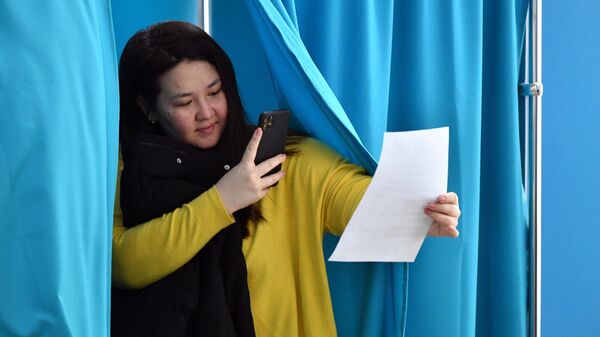 Девушка голосует на одном из избирательных участков в Астане на внеочередных выборах президента Казахстана