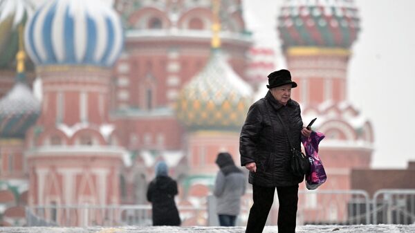 Пожилая женщина на Красной площади во время ледяного дождя в Москве