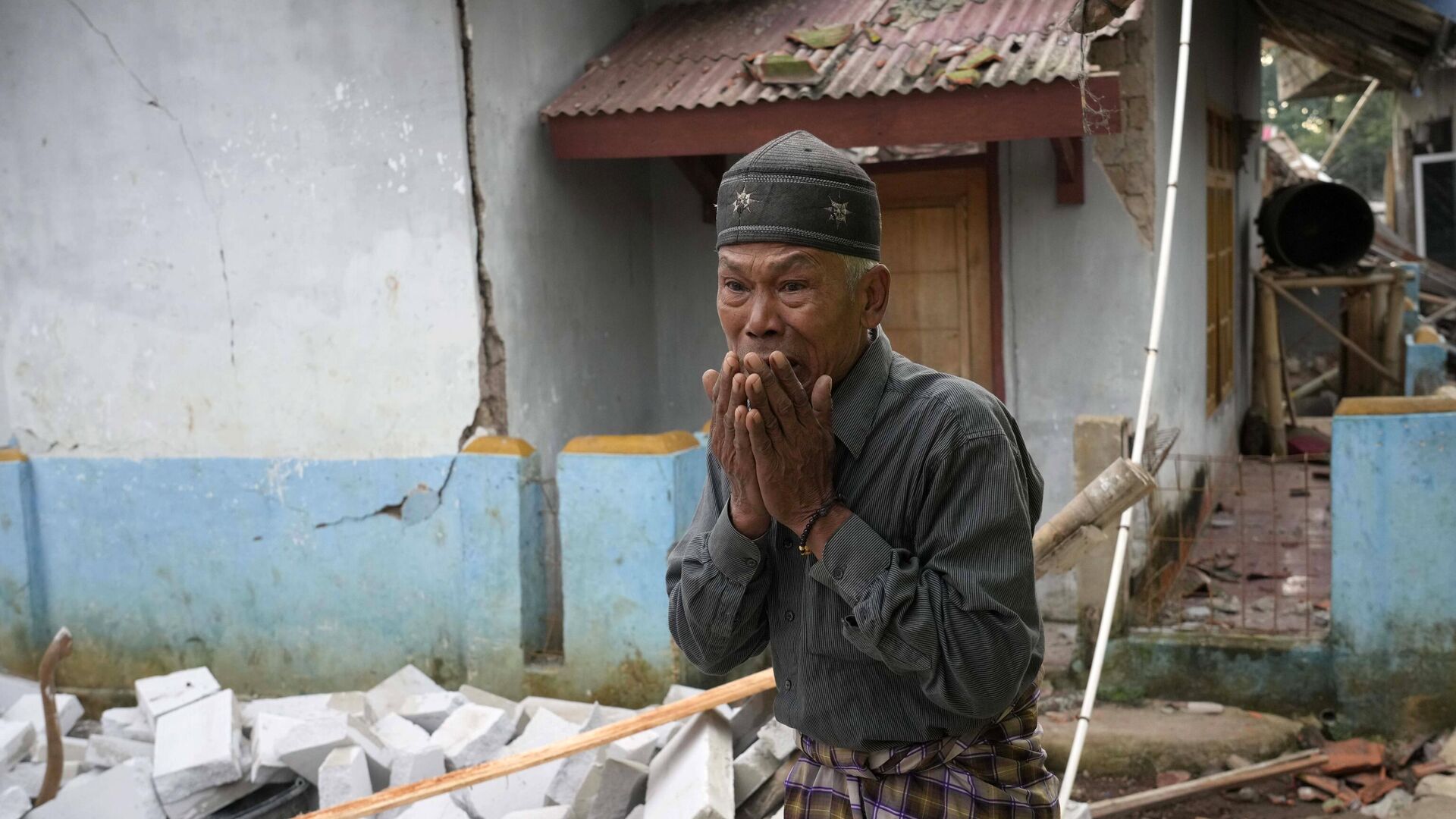 Мужчина на месте разрушения от землетрясения в провинции Западная Ява, Индонезия - РИА Новости, 1920, 22.11.2022
