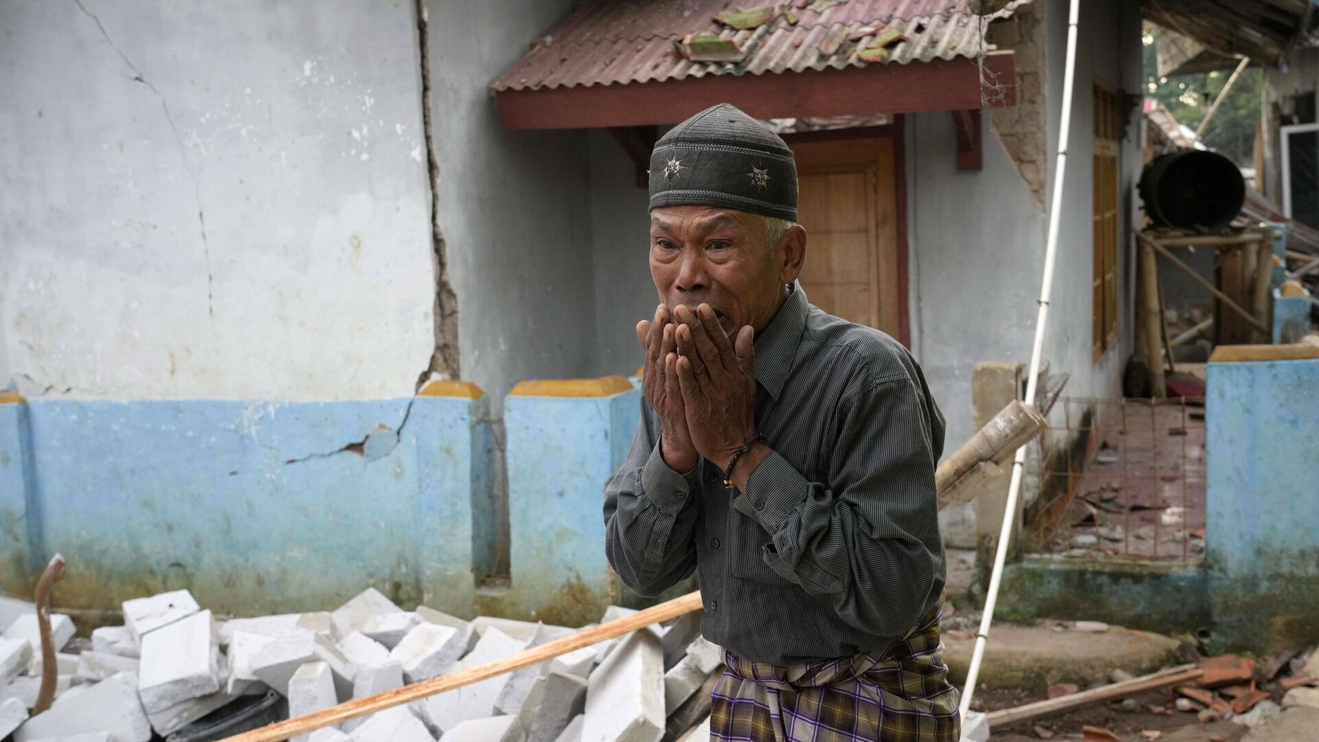 Мужчина на месте разрушения от землетрясения в провинции Западная Ява, Индонезия - РИА Новости, 1920, 22.11.2022