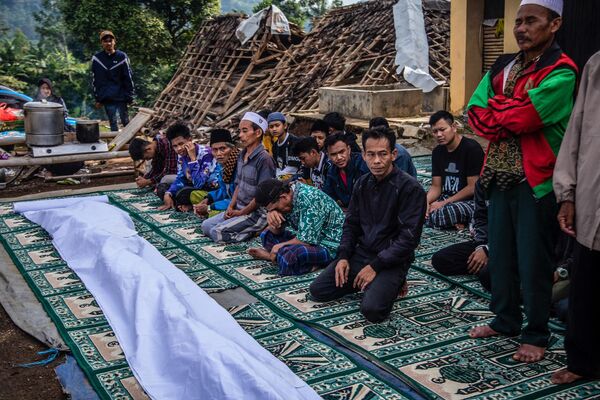 Жители деревни молятся после землетрясения в провинции Западная Ява, Индонезия