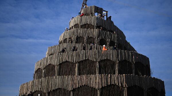 Посетители поднимаются на вершину арт-объекта Вавилонская башня архитектора Екатерины Поляковой на праздновании Масленицы в арт-парке Никола-Ленивец Калужской области