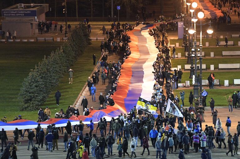 Люди несут 600-метровый сербско-российский флаг по улицам Санкт-Петербурга от станции метро Крестовский остров до стадиона, где состоится товарищеский матч между футбольными командами Зенит и Црвена Звезда