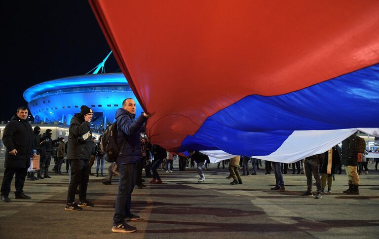 Люди несут 600-метровый сербско-российский флаг по улицам Санкт-Петербурга от станции метро Крестовский остров до стадиона, где состоится товарищеский матч между футбольными командами Зенит и Црвена Звезда