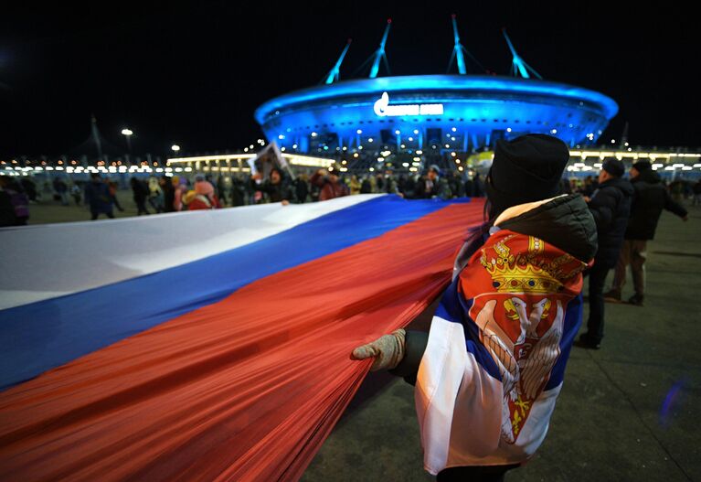 Люди несут 600-метровый сербско-российский флаг по улицам Санкт-Петербурга от станции метро Крестовский остров до стадиона, где состоится товарищеский матч между футбольными командами Зенит и Црвена Звезда