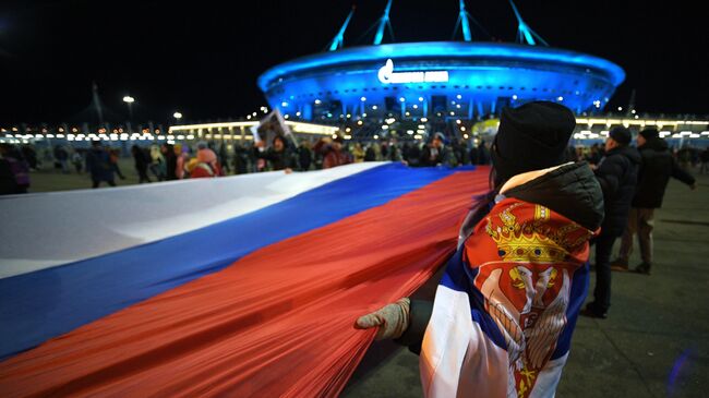 Люди несут 600-метровый сербско-российский флаг по улицам Санкт-Петербурга от станции метро Крестовский остров до стадиона, где состоится товарищеский матч между футбольными командами Зенит и Црвена Звезда