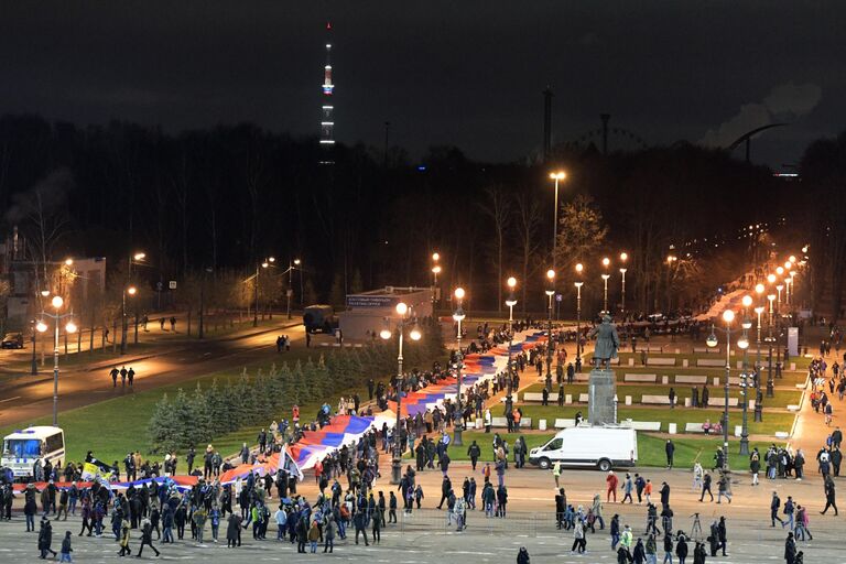 Люди несут 600-метровый сербско-российский флаг по улицам Санкт-Петербурга от станции метро Крестовский остров до стадиона, где состоится товарищеский матч между футбольными командами Зенит и Црвена Звезда