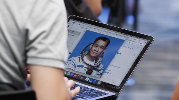 Журналист смотрит на фотографию астронавта Не Хайшэна во время пресс-конференции, Китай