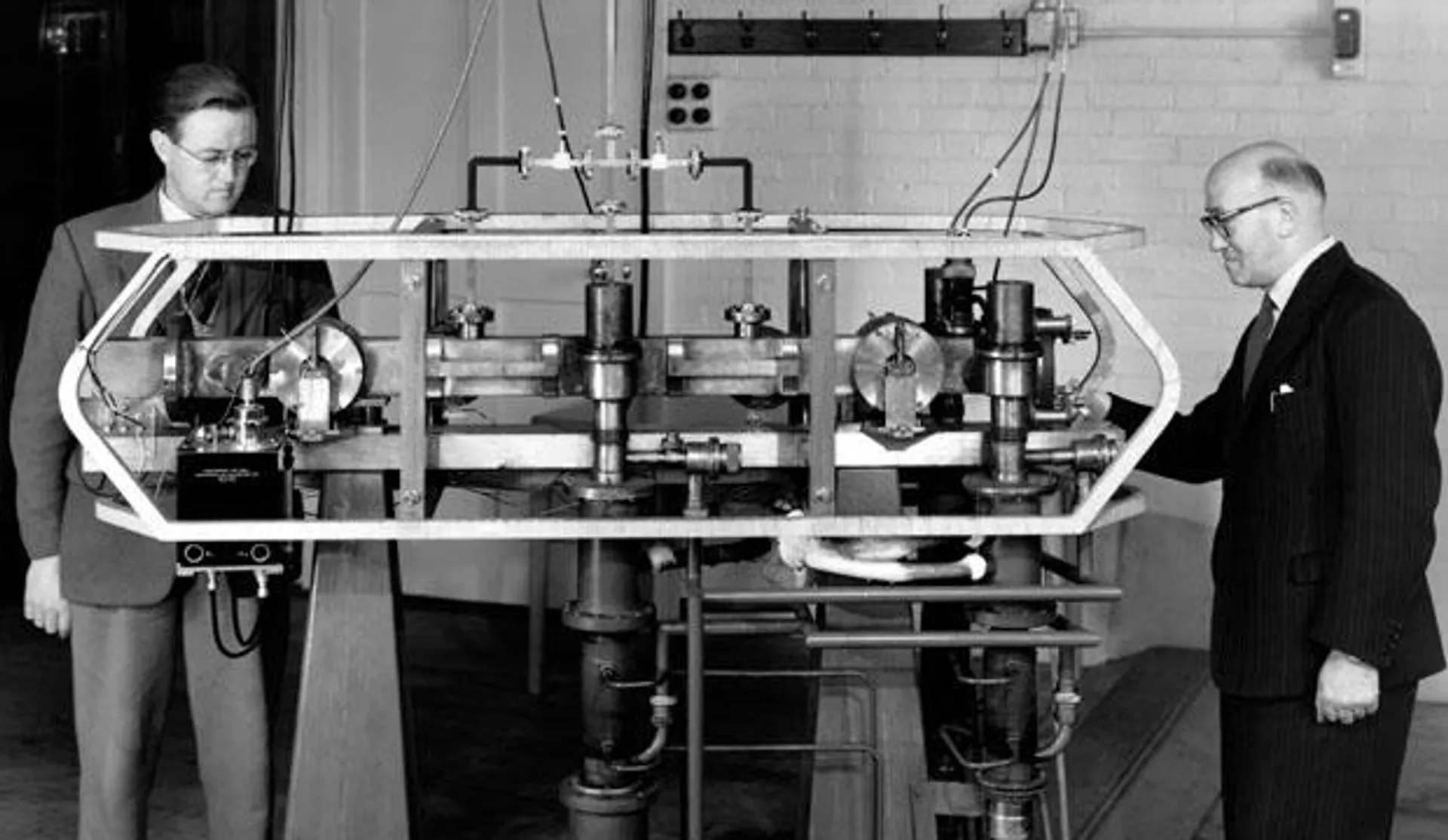 Луис Эссен и Дж. Парри рядом с первыми в мире цезиевыми атомными часами, разработанными в Национальной физической лаборатории Великобритании в 1955 году - РИА Новости, 1920, 24.11.2022