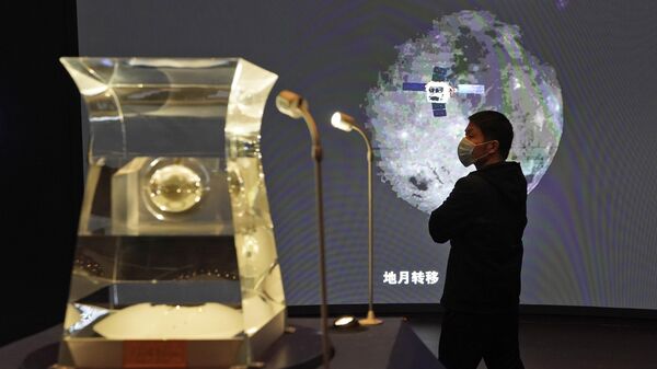 Посетитель Национального музея смотрит на выставку образцов лунных пород, извлеченных с Луны китайским лунным модулем Чанъэ-5 в Пекине.