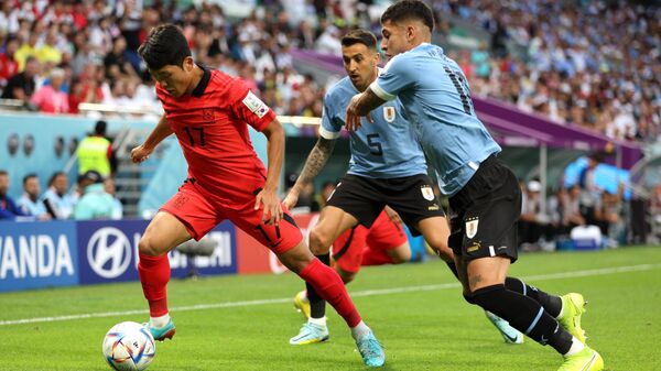 Футболисты сборной Южной Кореи (в красном) и Уругвая (в голубом)