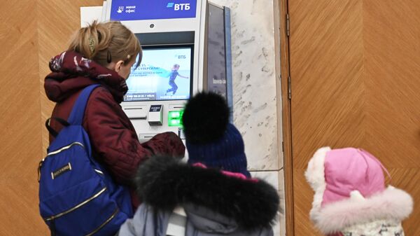 Женщина с детьми у банкомата