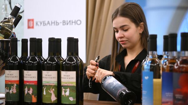 Девушка открывает бутылку вина на первом Российском винодельческом форуме в Москве