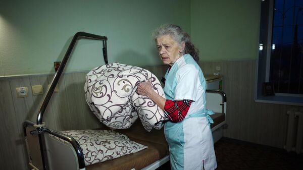 Доброволец Наталья Пасика перестилает постель в палате госпиталя в Луганске