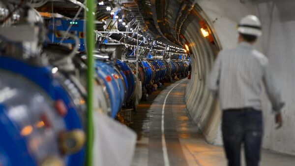 Сотрудник проходит вдоль Большого Адронного Коллайдера в туннеле Европейской организации ядерных исследований (ЦЕРН)