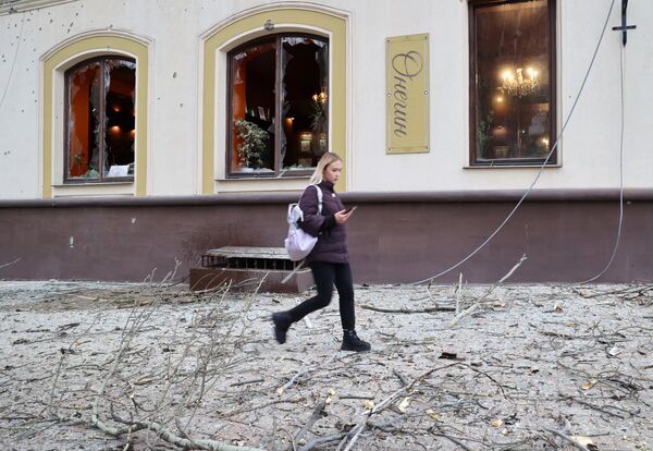 Девушка у поврежденного кафе в Ворошиловском районе Донецка после обстрелов со стороны ВСУ
