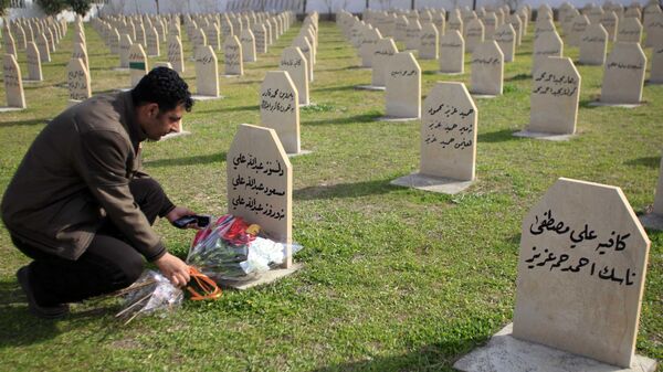 Мужчина возлагает цветы на могилу жертвы химической атаки 1988 года в городе Халабджа на севере Ирака