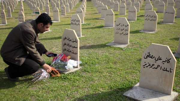 Мужчина возлагает цветы на могилу жертвы химической атаки 1988 года в городе Халабджа на севере Ирака