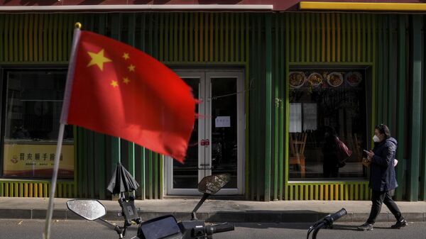 Женщина проходит мимо закрытого из-за ковидных ограничений ресторана в Пекине, КНР