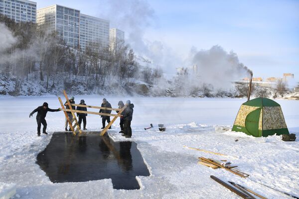 Подготовка проруби для зимнего плавания на озере Блюдце в Новосибирске