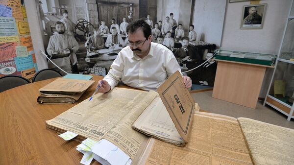 Сотрудник разбирает папки с документами в Государственном архиве Челябинской области