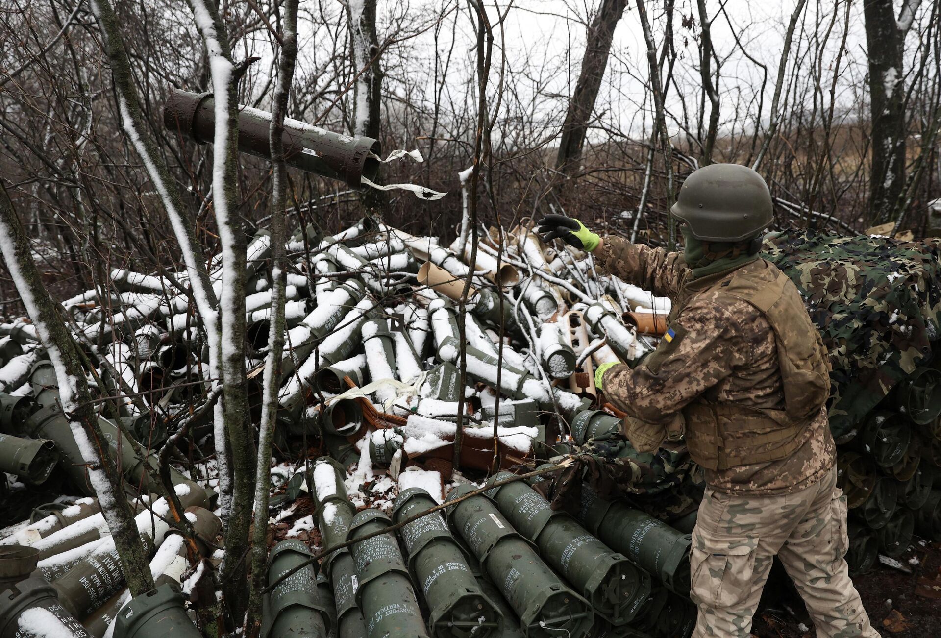 Украинский военный выкидывает пустую 155мм гильзу от американской гаубицы М777 - РИА Новости, 1920, 30.11.2022