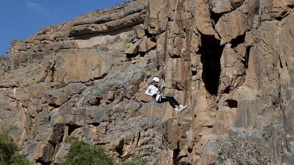 Турист во время посещения деревни Мисфат-аль-Абрин на склонах Гранд Каньона в Омане