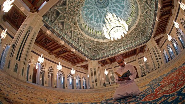 Оманец читает Коран в мечети Султана Кабуса в Маскате