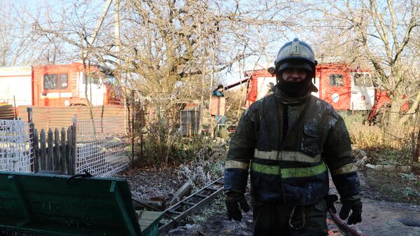 Сотрудник пожарной службы МЧС ДНР работает на месте пожара в жилом доме в Киевском районе Донецка после обстрела ВСУ