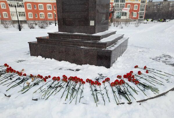 Цветы у мемориала Добрый Ангел мира в память о погибших при частичном обрушении жилого дома на улице Мира в Нижневартовске