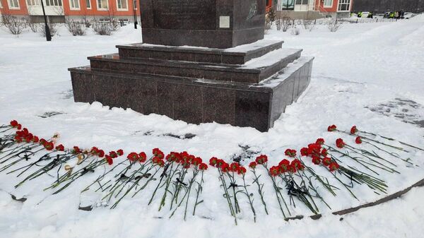 Цветы у мемориала Добрый Ангел мира в память о погибших при частичном обрушении жилого дома на улице Мира в Нижневартовске