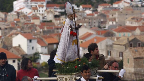 Верующие несут статуэтку Святого Николая во время Крестного хода, посвященного дню Святого в городе Комижа в Хорватии