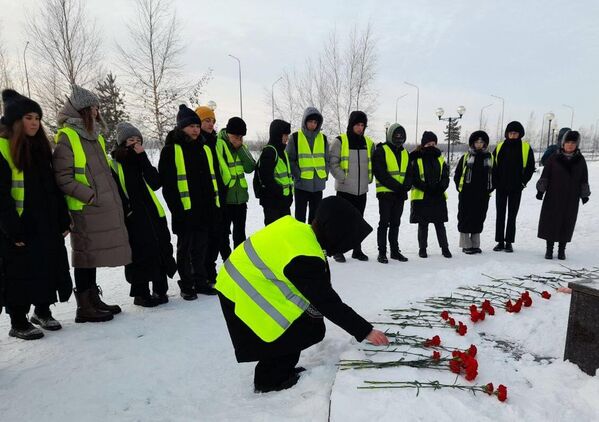 Люди возлагают цветы к мемориалу Добрый Ангел мира в память о погибших при частичном обрушении жилого дома на улице Мира в Нижневартовске